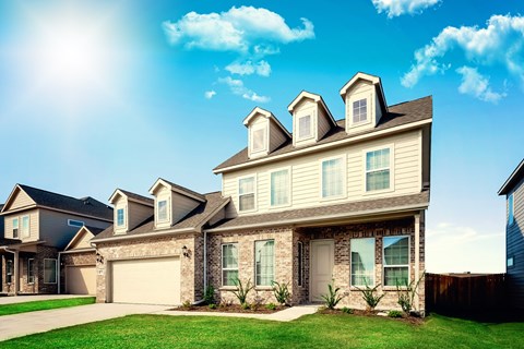 a house with two dormer windows and two garage doors